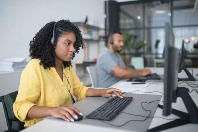 Two customer service agents working with headsets in a modern office setting. The honest guide to an invented customer ethics case study